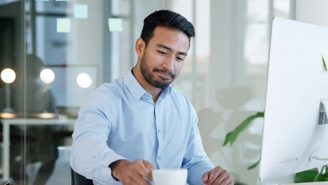 Relaxed and happy business man drinking coffee and reading email on computer in modern office. Professional excited about good news or feedback. Cheerful guy feeling positive about an idea