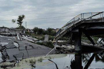 Irpen, Kyiv region, Ukraine - July 18, 2022: Remains of a blown up bridge that collapsed during the Russian-Ukrainian war. River under the bridge. Reportage editorial photography