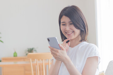 Fototapeta premium スマートフォンを操作する笑顔の女性