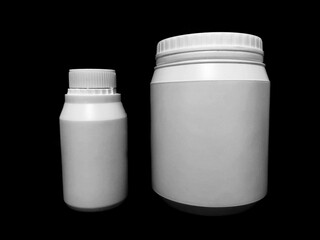 Empty plastic white bottles on a dark background.