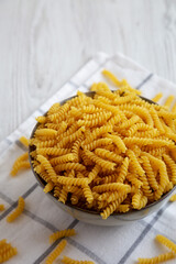 Uncooked dry girandole torsades pasta in a bowl, side view.