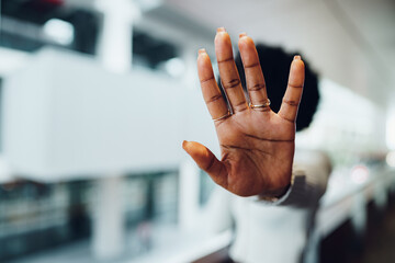 Portrait of a serious young african woman showing stop gesture with her palm in urban background