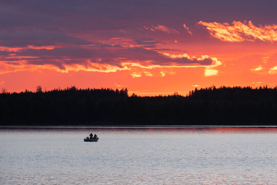 Zander Angler in der Dämmerung im Boot am Furen See in Schweden.