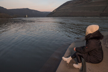 Frau am Rheinufer Bingen im Sonnenaufgang