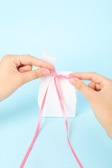 Concept of gift, female hands and gift bag on blue background