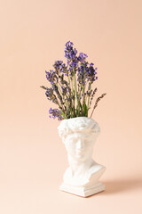 Ancient statue head with beautiful lavender flowers