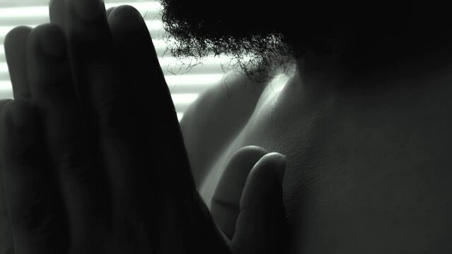 Religion man praying to God for hope with sun light coming from the side face. closeup shot