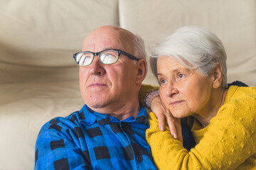 Relaxed loving married elderly man and woman hugging and ooking away, wife resting on her husband's...