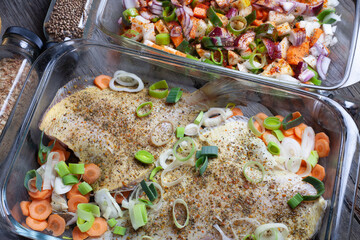 raw sea fish (flounder) on a glass tray with vegetables. top view