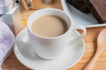 Hot coffee latte in a white coffee mug with cake.Breakfast