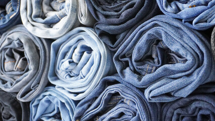 Stack of Various Shades of Rolled Up Denim Jeans Background Banner Texture. 