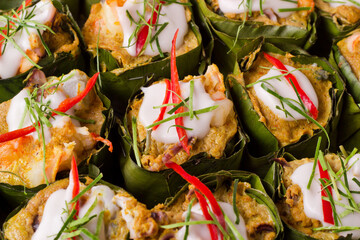 Thai steamed curry fish in banana leaf cups decorated with red chilli, (Hor Mok Pla)