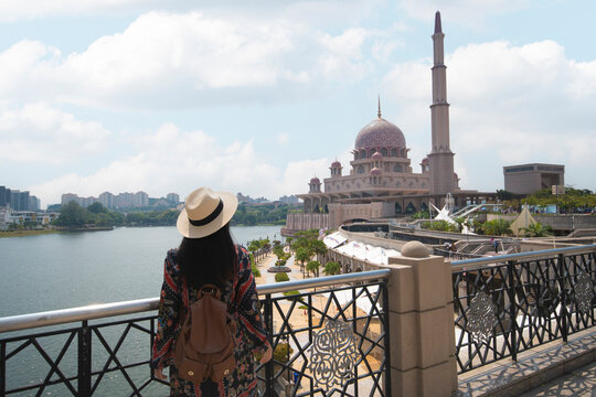 Woman tourist is sightseeing Putrajaya Mosque during travel in Malaysia.
