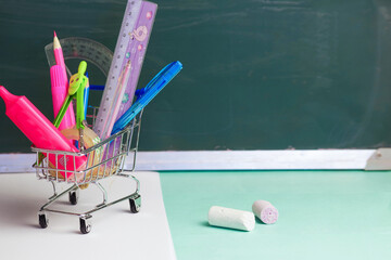 in a cart from a hypermarket there are many different school supplies on the background of a...