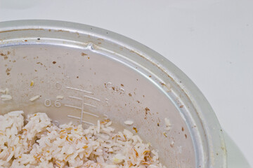 Brown rice in electric rice cooker isolated on a white background