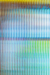 Abstract wave glass vertical line pattern background. Texture of wavy glass illuminated with...