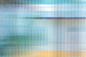 Abstract wave glass vertical line pattern background. Texture of wavy glass illuminated with...