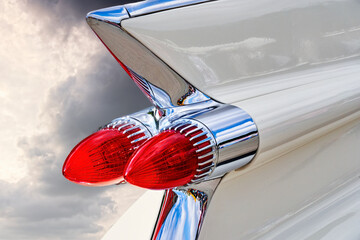 Red conical tail lights on the white fin on the stern of an American classic road cruiser
