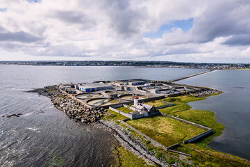 Fototapeta na wymiar View on Mutton Island and causeway. Galway city, Ireland. Popular town landmark with water treatment plant and old lighthouse and good view on the city. Aerial image.