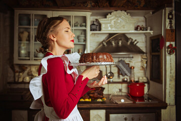 Housewife holding a chocolate kuglof-marble cake in the kitchen, 50s retro style 