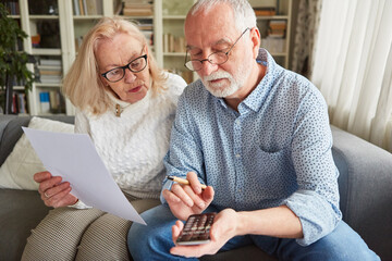 Senioren mit Taschenrechner berechnen Kosten der Pflege