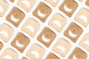 Creative emoji pattern made of slices of white and whole-grain brown toast bread on isolated pastel white background. Minimal flat lay texture. The concept of health benefits or food comparison.
