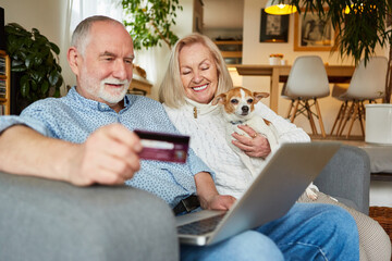 Glückliches Senioren Paar am Laptop mit Kreditkarte