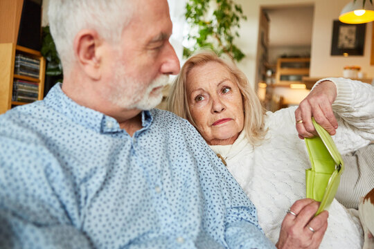 Besorgtes Senioren Paar mit leerer Geldbörse zu Hause