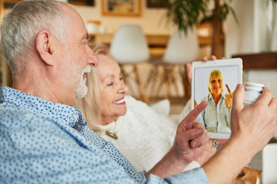 Ärztin berät krankes Senioren Paar am Tablet Computer