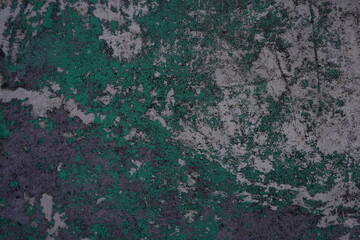 Old concrete wall mottled with traces of past paint layers of green and silver color. Grunge design background