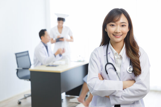 Portrait Of Young Beautiful Cheerful Young Female Doctor Smiling With Doctor Nurse And Patient Interaction Together Background