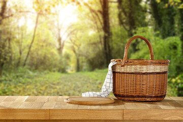 Basket on wooden table and forest landscape. 