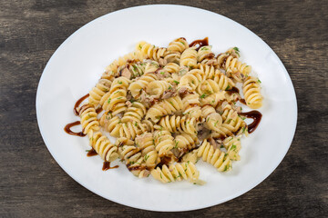 Prepared spiral pasta with chopped meat and dill on dish