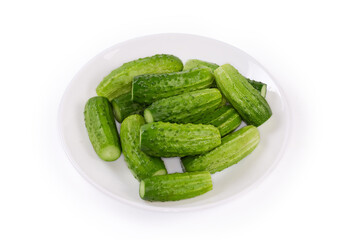 Whole cucumbers on a dish on a white background