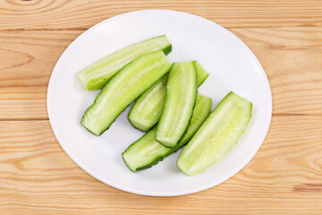 Halved small cucumbers on a dish on a rustic table