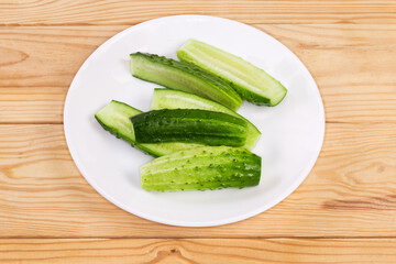 Halved small cucumbers on a dish on a rustic table