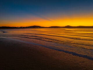 Aerial sunrise seascape with orange glow on a cold Winter's morning