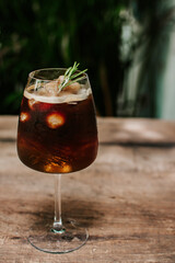Colorful cocktail of longan juice with espresso coffee with fresh longan on wooden background. Trendy summer coffee drink. Copy space for text.