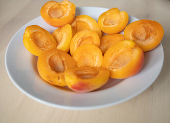ripe, juicy apricots lie on a white plate. Energy boost, vitamins, ripe fruits, pesticides. Interruptions in the supply of fruits, imports of apricots