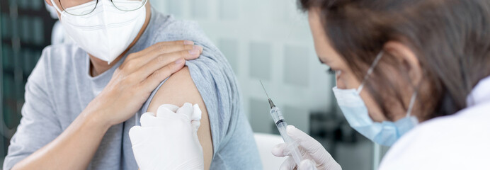 Doctor vaccinating patient, vaccination against new strains of virus, Doctor holding a syringe,...