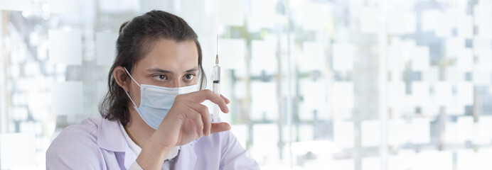 Doctor holding a syringe containing a respiratory viral vaccine or anti-influenza medication,...