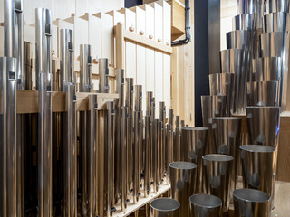 Inside a contemporary organ in modern philharmonic hall, register with different steel pipes. structure of organ