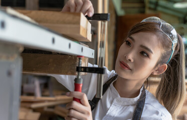 Young Asian carpenter working with tools in carpentry woodworking workshop, Carpenter concept