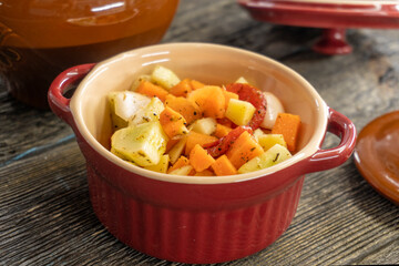 stewed vegetables in a clay pot on a wooden background. food concept.