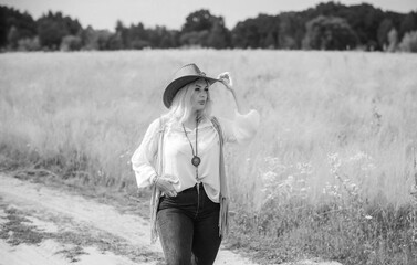 Woman Plus size in American country style black boho jacket, with a fringe, shirt and cowboy hat at...