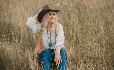 Woman Plus size in American country style black boho jacket, with a fringe, shirt and cowboy hat at...