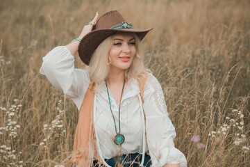 Woman Plus size in American country style black boho jacket, with a fringe, shirt and cowboy hat at...