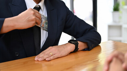 A businessman take a dollar money banknote into his suit pocket. cropped image
