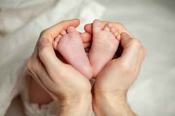 Father holding his adorable baby girl feet closeup