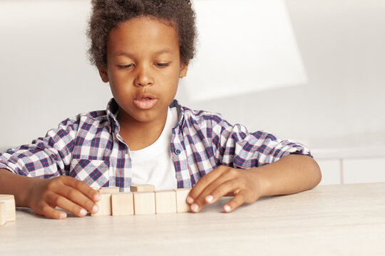 Smart kid playing empty wooden cubes